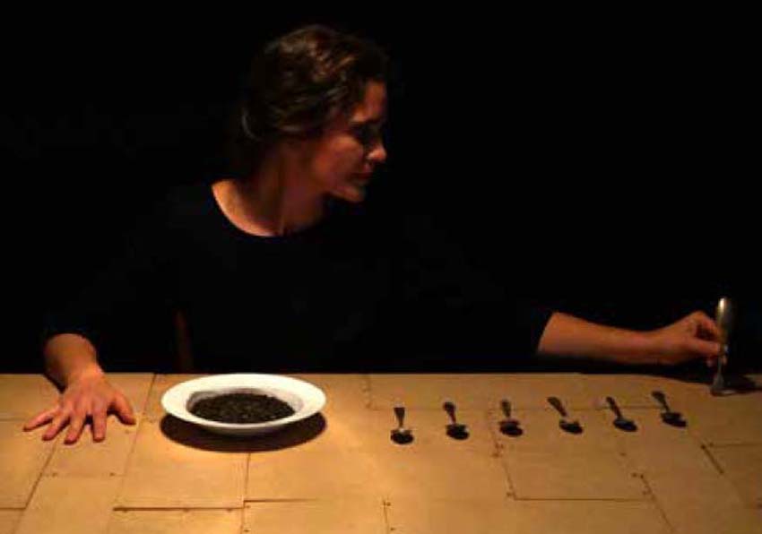 Actress sitting in front of a plate and kitchen cutlery